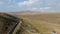 Aerial view of scenic road in the middle of green desert valley in Mono County