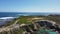 Aerial view of a scenic rocky coastline with a road against the azure sea in Cape Town, South Africa