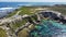 Aerial view of a scenic rocky coastline with a road against the azure sea in Cape Town, South Africa