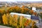 Aerial view of school, college or kindergarten building with big yard among autumn trees on rural landscape background