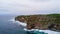 Aerial view of sea rocky coast with surf the waves, Bali, Indonesia, Pura Uluwatu cliff. Waves crushing rocky shore. Seascape,