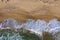 Aerial view of sea waves and a remote secluded sandy beach