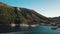Aerial view on seashore of Lipari Island. Green trees and buildings, mountains and blue sky. Moored sailing yachts and