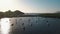 Aerial view on seashore of Lipari Island. Green trees and buildings. Mountains and sunrise. Yachts, catamarans and boats