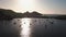 Aerial view on seashore of Lipari Island. Green trees and buildings. Mountains and sunset. Yachts, catamarans and boats