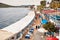 Aerial view of seaside fish restaurants of gumusluk coastline in bodrum, turkey and people walking on the road