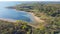 Aerial view a secondary point or hump surrounding by lush green trees and curved sandy shoreline at Isle du Bois Ray Roberts Lake