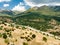 Aerial view of serpentine road snaking between mountains in West Greece. A road full of twists and turns winding sharply up the