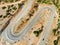 Aerial view of serpentine road snaking between mountains in West Greece. A road full of twists and turns winding sharply up the
