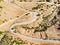 Aerial view of serpentine road snaking between mountains in West Greece. A road full of twists and turns winding sharply up the