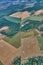 an aerial view of several land areas, including crops, fields and roads