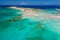 Aerial view of shallow sandy lagoons and a beach surrounded by deeper dark blue sea Elafonissi Beach