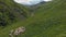 Aerial view of sheep flock traveling on a greenery alpine meadow at the Bear Cross Pass. Herd of sheeps in Khevsureti