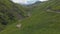 Aerial view of sheep flock traveling on a greenery alpine meadow at the Bear Cross Pass. Herd of sheeps in Khevsureti