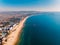 Aerial view of shore with pier, city and quit sea