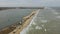 Aerial view showcases kiteboarders gliding over waves at popular beach spot. Extreme sports enthusiasts harness wind