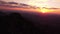 Aerial view, silhouette of a mountain in a hilly landscape at sunset. Rotating movement