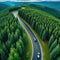 Aerial view of a single car driving along the curvy road going through a forest and