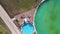 Aerial view sinking down and spinning on small children who play and bathe in a special children`s pool with a small inflatable wa