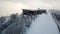 Aerial view of ski resort outdoors in winter. Stock footgage. Foggy mountain slope and the group of people preparing to