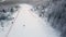 Aerial view of ski resort with people snowboarding down the hill. Stock footage. Flying over the ski or snowboard track