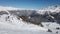 Aerial view of ski slope and skiers skiing down the slope during sunny day during winter holidays