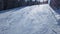 Aerial view of ski slope and skiers skiing down the slope during sunny day during winter holidays