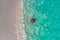 Aerial view of slim woman swimming on the swim ring donut in the transparent turquoise sea in Seychelles. Summer seascape with