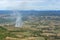Aerial view of small area fire In the agricultural area With mountains on the horizon On a sunny day
