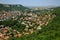 Aerial view of a small, beautiful green city with a lot of trees, situated in a deep karst gorge on a bright summer day. Town of P