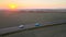 Aerial view of small cargo van driving on highway hauling goods at sunset. Delivery transportation and logistics concept