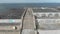 Aerial view of a small empty sea port. Stock. Flying over people walking on concrete walkway and stairs of the pier on