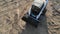 Aerial view small excavator carries a small mountain of rubble. View from a drone on an excavator that carries rubble