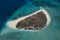 Aerial view of small exotic island surrounded by coral reef and blue sea