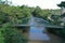 Aerial view of a small footbridge made of steel that crosses a small tropical river in the city of Puyo