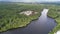 Aerial view of a small river with trees and houses on the shore