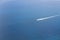 Aerial view of a small ship navigating at a blue ocean