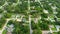 Aerial view of small town America suburban landscape with private homes between green palm trees in Florida quiet