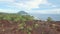 Aerial view of small tropical island with volcano and reddish frozen lava soil