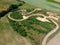 Aerial view on snake shape dirt racetrack for off road vehicles, rural surroundings