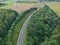 Aerial view on snake shape road, wheat fields and forest