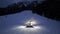 Aerial view of snowcat on the snowy alpine ski slope at night