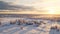 Aerial View Of Snowy Landscape Over Village At Sunrise