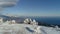 Aerial view of snowy mountains, sea, cloudy sky. Shot. Snow-covered hills by the sea