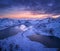 Aerial view of snowy mountains, sea, colorful cloudy sky at night