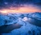 Aerial view of snowy mountains, sea, colorful sky at sunset