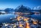 Aerial view of snowy village, city lights, sea, mountain at night