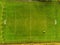 Aerial view, soccer or football field under maintenance, Tractor with feeder and trail all over the pitch