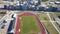 Aerial view of a soccer stadium with green grass in a city.