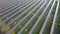 Aerial view of solar power plant under construction on green field. Assembling of electric panels for clean ecologic